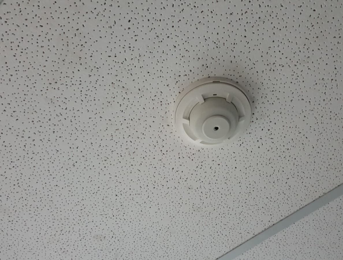 A White Smoke Detector Is Mounted To A White Ceiling — Mozzlec Electrical & Airconditioning In Urangan, QLD
