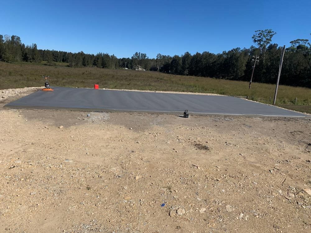 A Large Concrete Slab In The Middle Of A Dirt Field  — Brodie Wynter Concreting in Forster, NSW