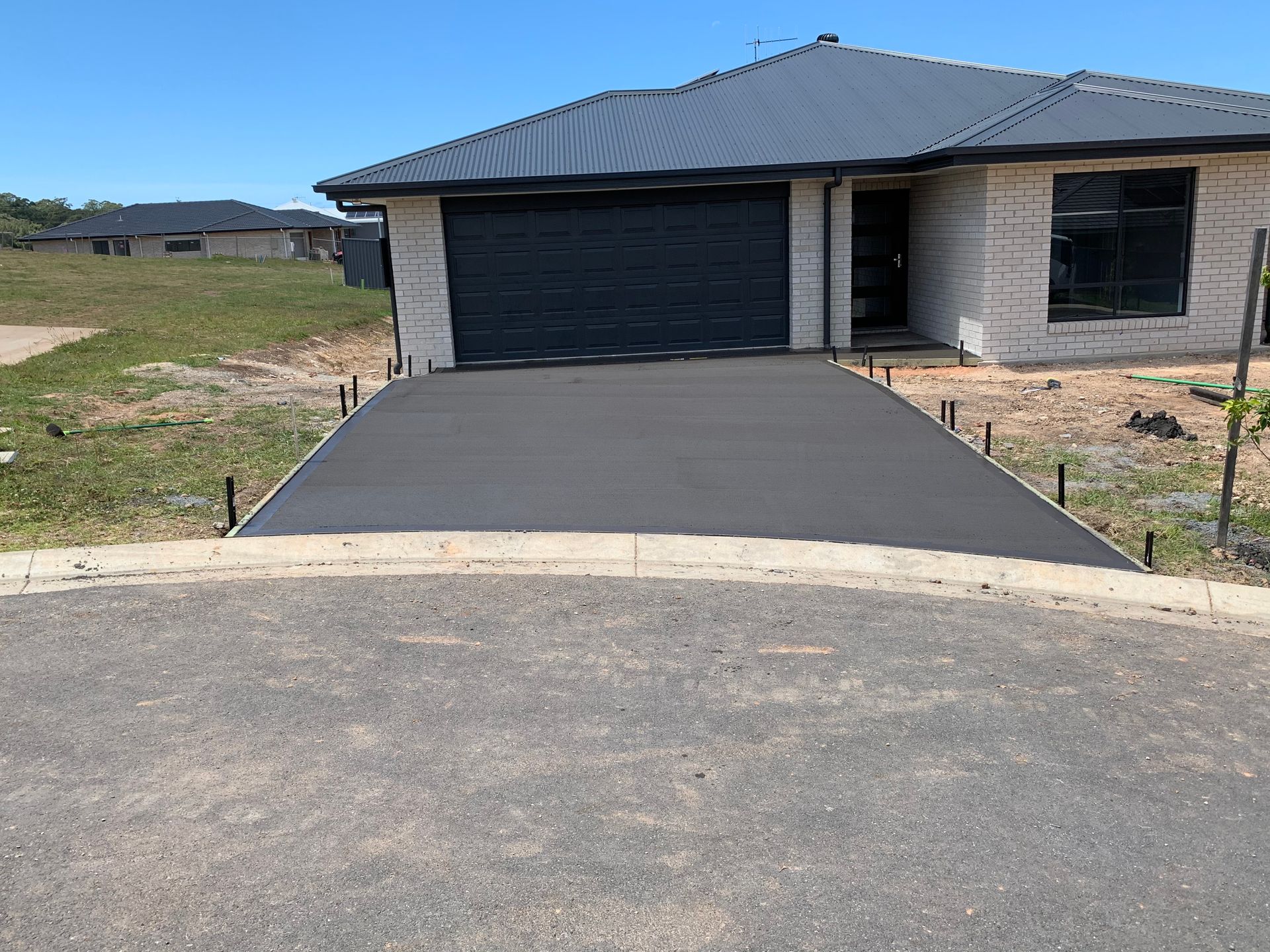 A Concrete Driveway Is Being Built In Front Of A House  — Brodie Wynter Concreting in Port Macquarie, NSW