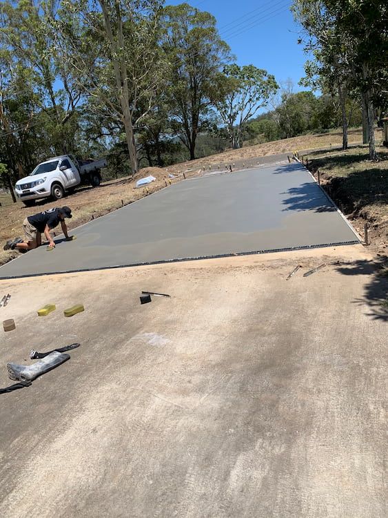 A Man Is Working On A Concrete Driveway  — Brodie Wynter Concreting in Harrington, NSW