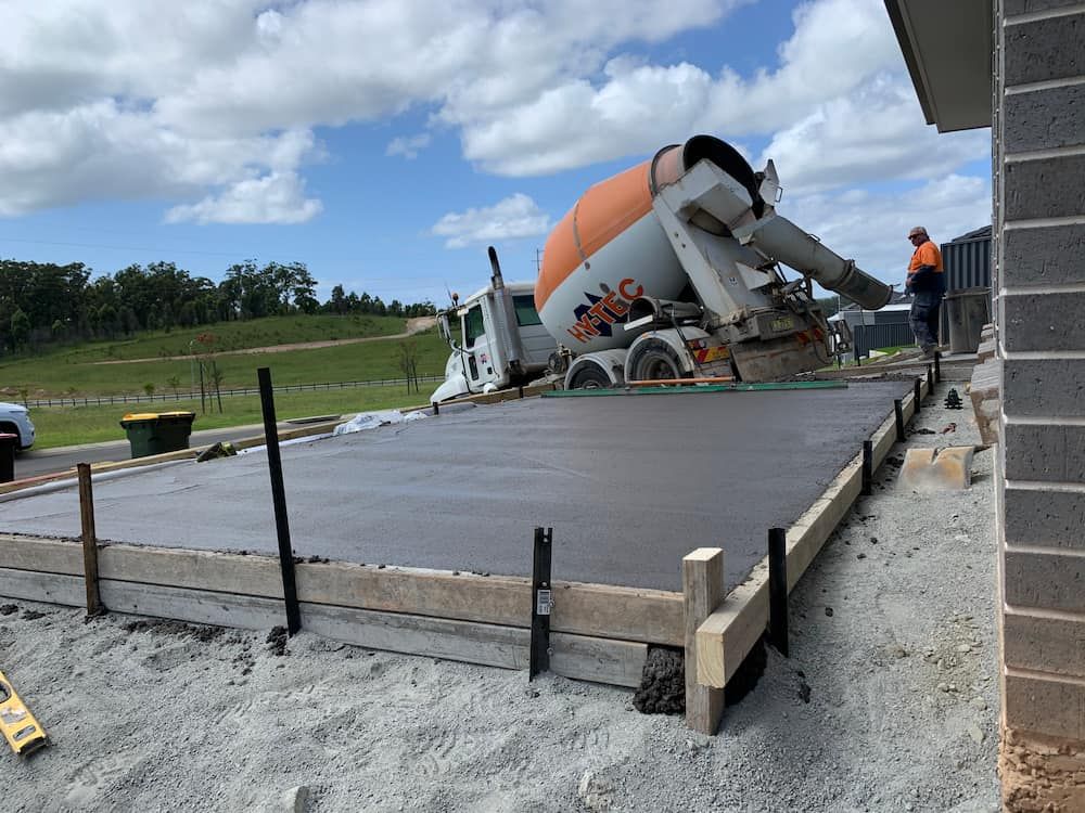 A concrete truck is pouring concrete into a concrete slab — Brodie Wynter Concreting in Port Macquarie, NSW