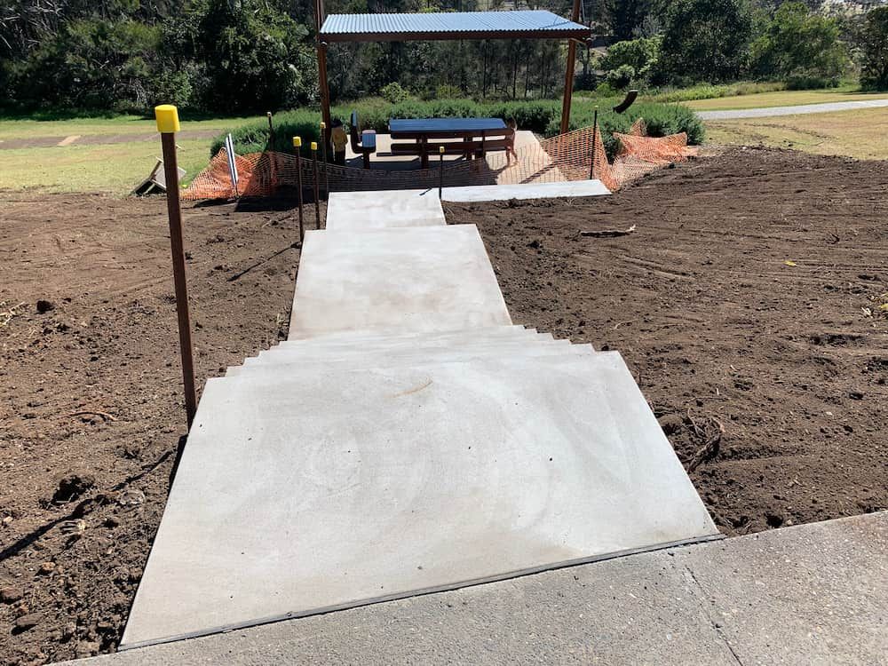 A Concrete Walkway Leading To A Picnic Table In A Park — Brodie Wynter Concreting in Wauchope, NSW