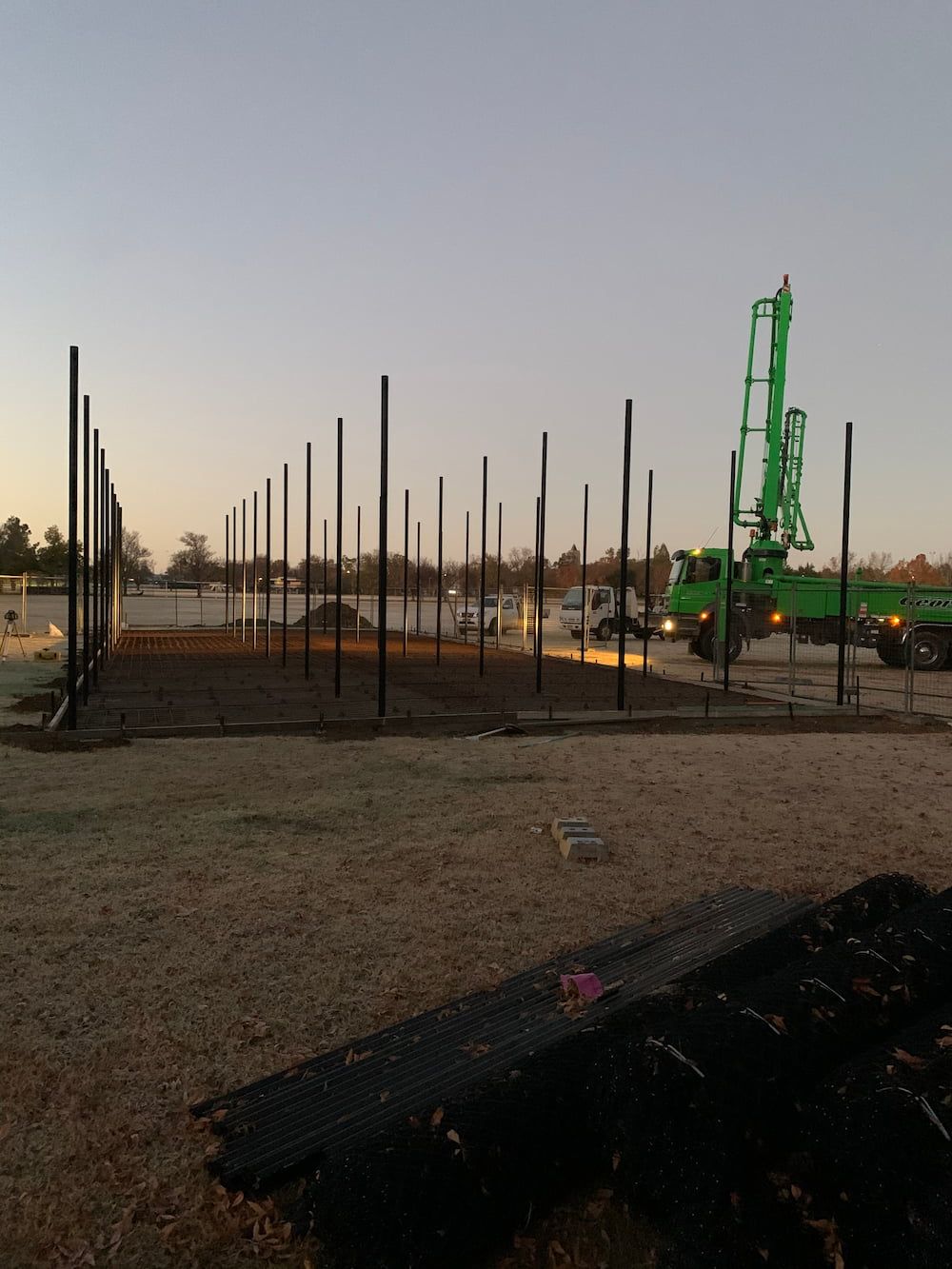 A Green Truck Is Pumping Concrete Into A Construction Site — Brodie Wynter Concreting in Coffs Harbour, NSW
