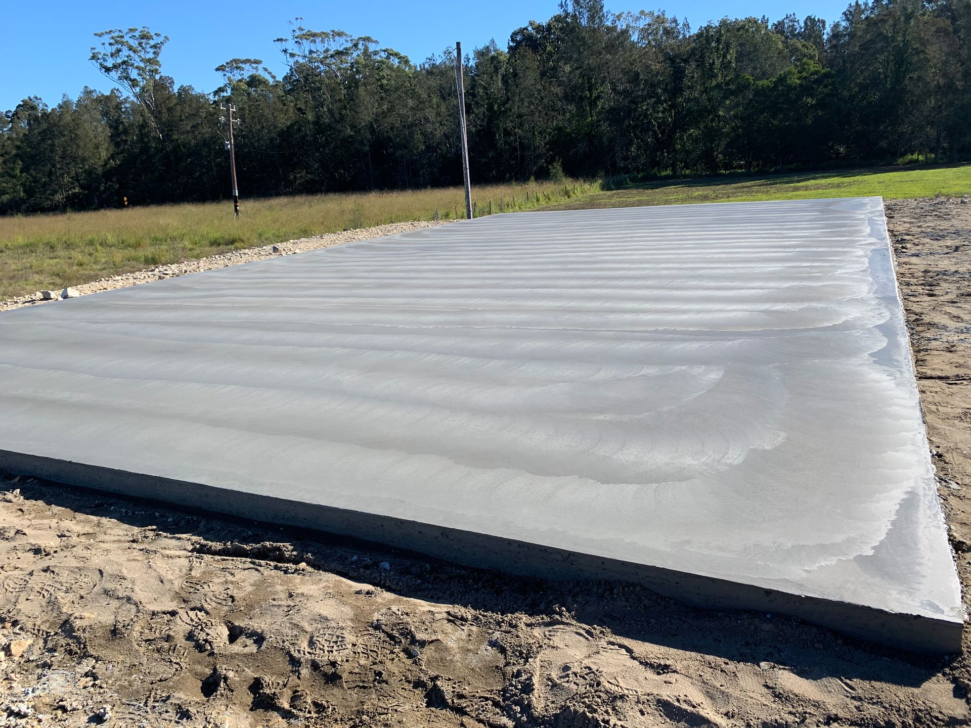 A Man Is Working On A Concrete Driveway  — Brodie Wynter Concreting in Macksville, NSW