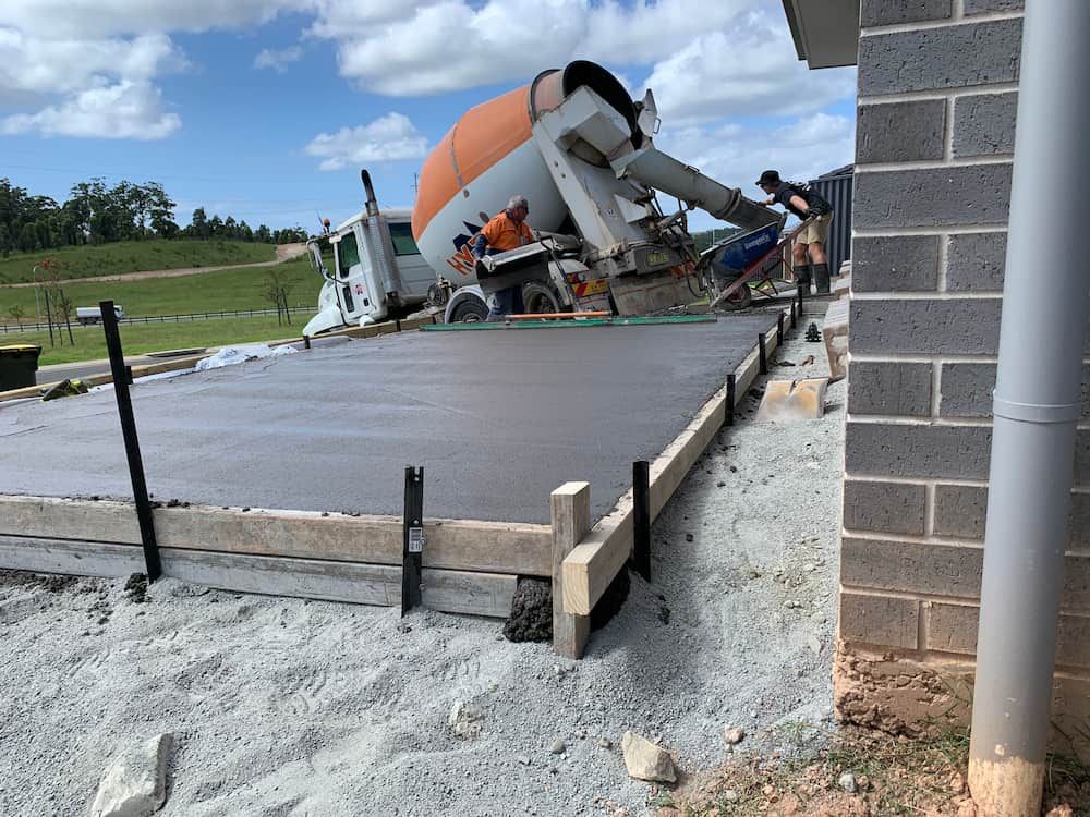 A Concrete Truck Is Pouring Concrete Into A Concrete Slab — Brodie Wynter Concreting in Coffs Harbour, NSW