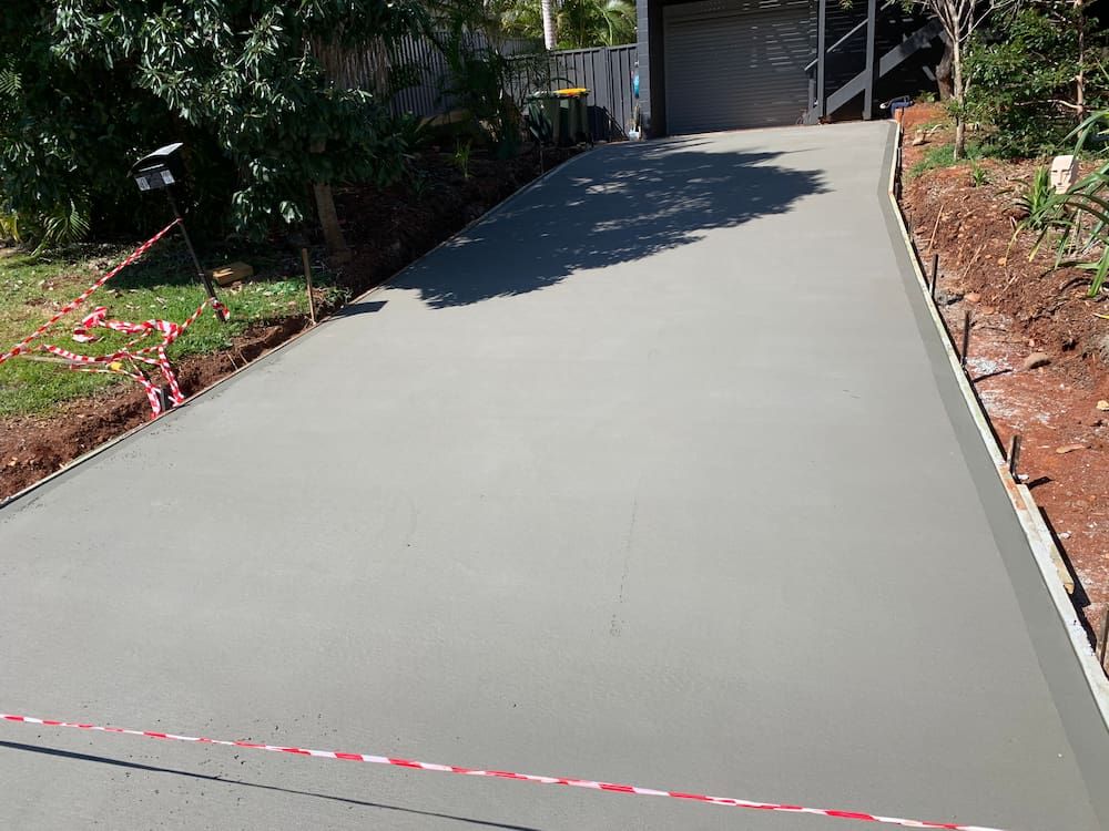 A Concrete Driveway Is Being Built In Front Of A Garage — Brodie Wynter Concreting in Wauchope, NSW