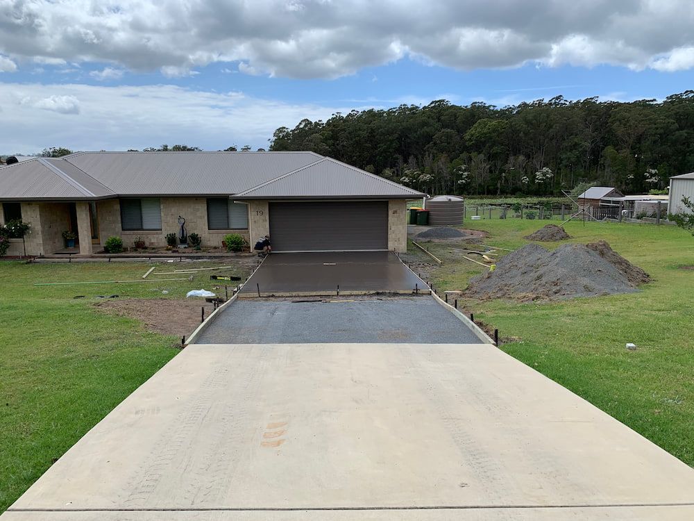 A House With A Concrete Driveway In Front Of It  — Brodie Wynter Concreting in Port Macquarie, NSW
