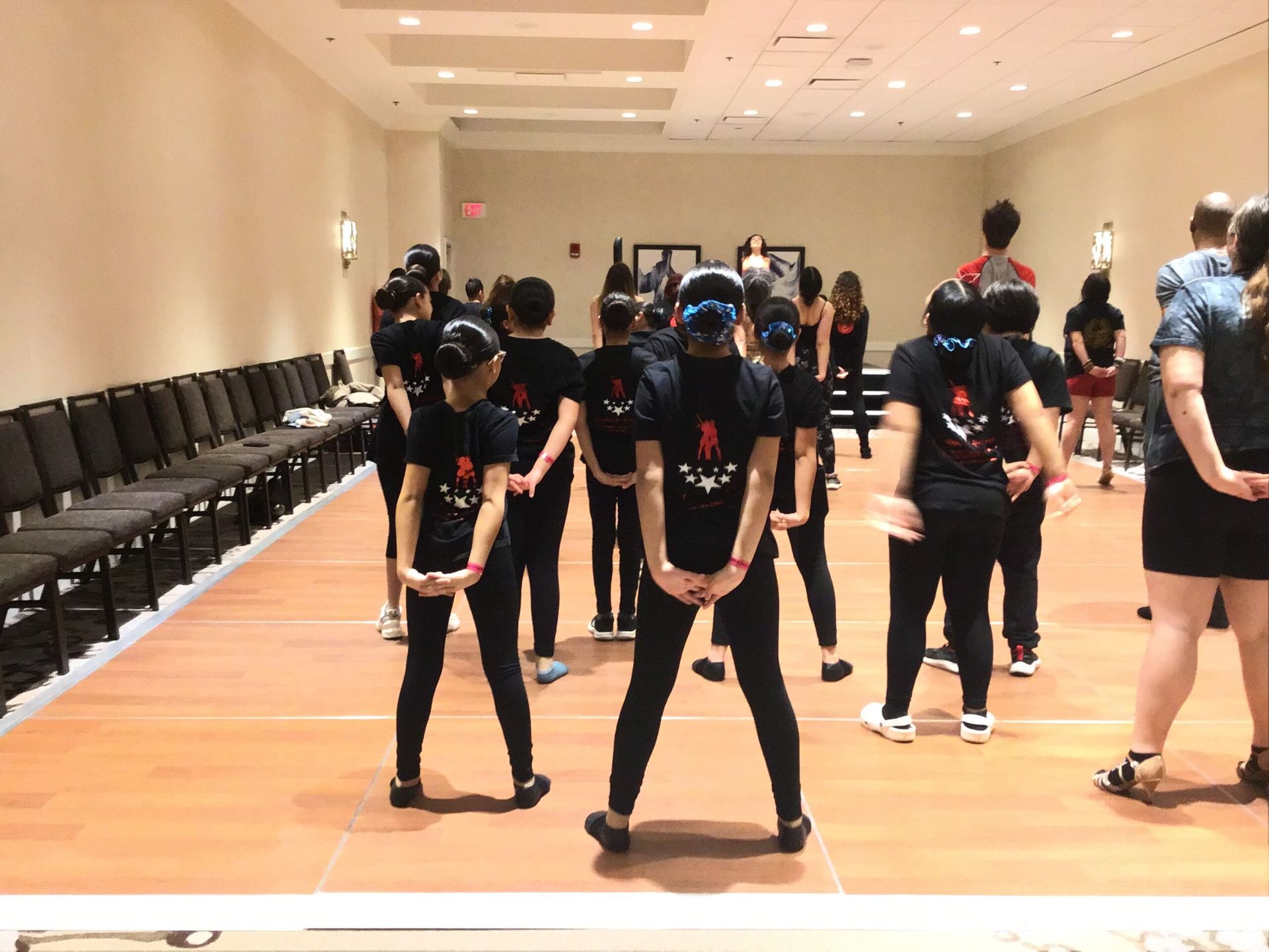 A group of people are standing on a dance floor