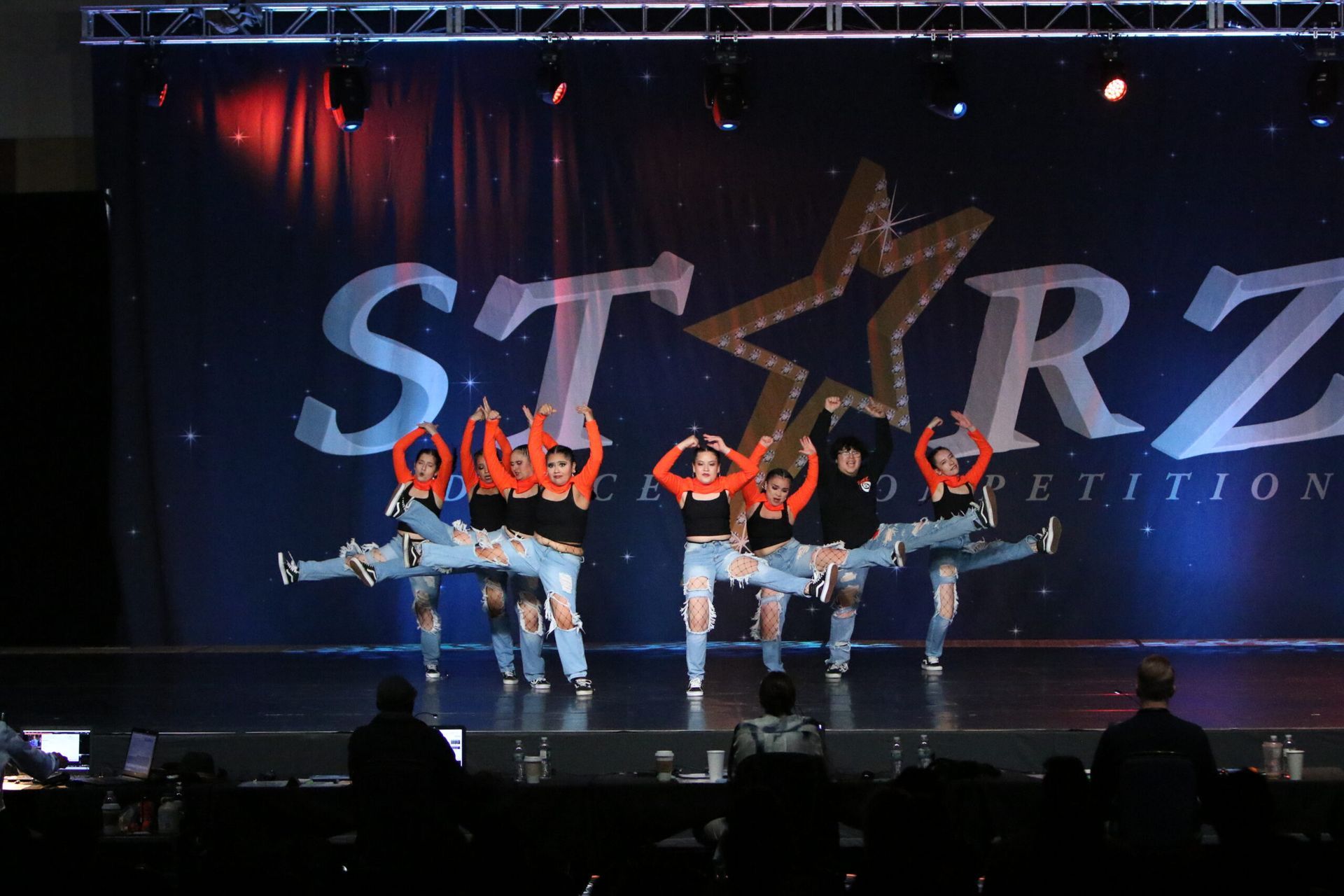 A group of dancers are performing in front of a starz logo