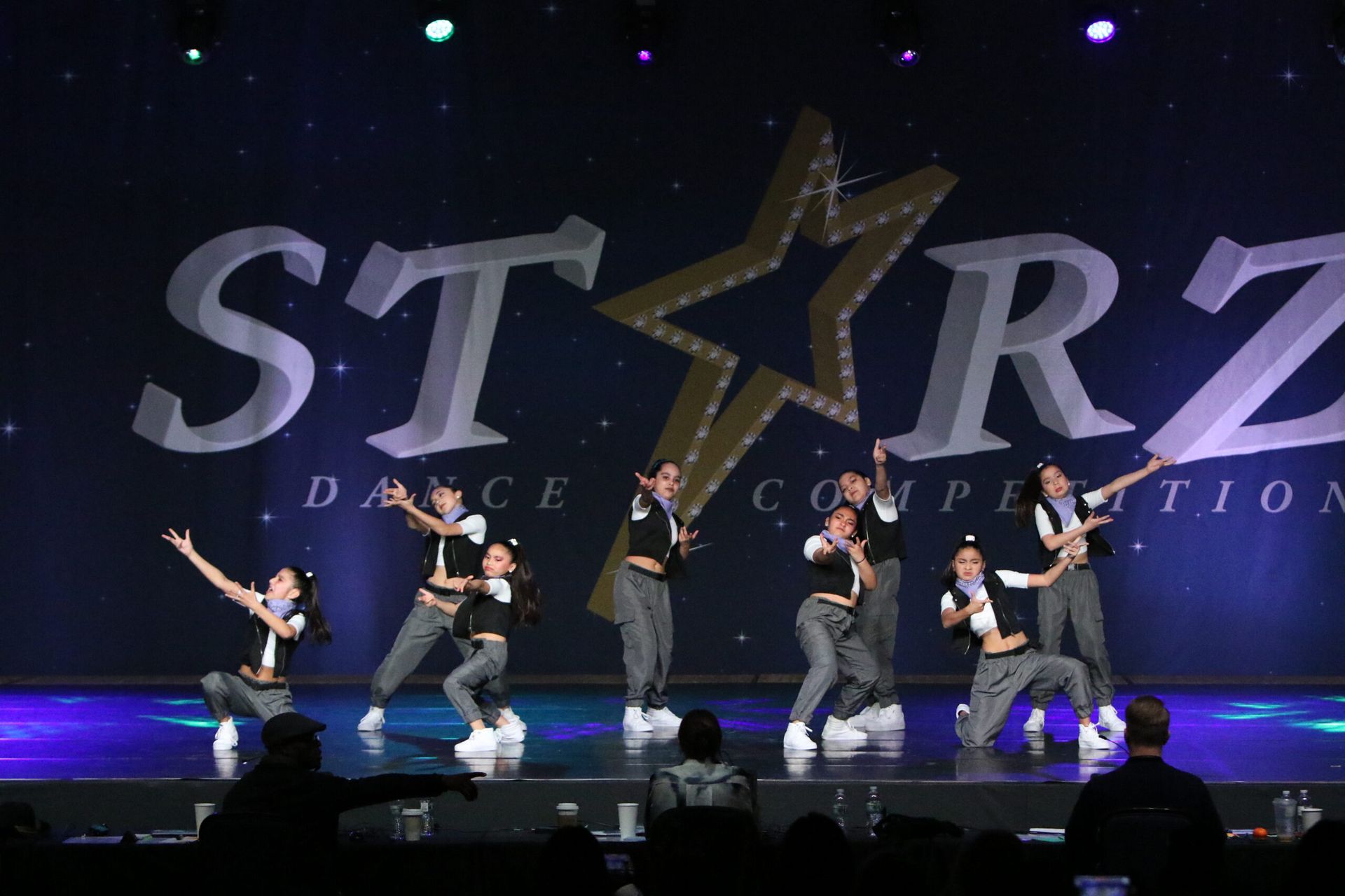 A group of people are dancing on a stage in front of a starz dance competition sign.