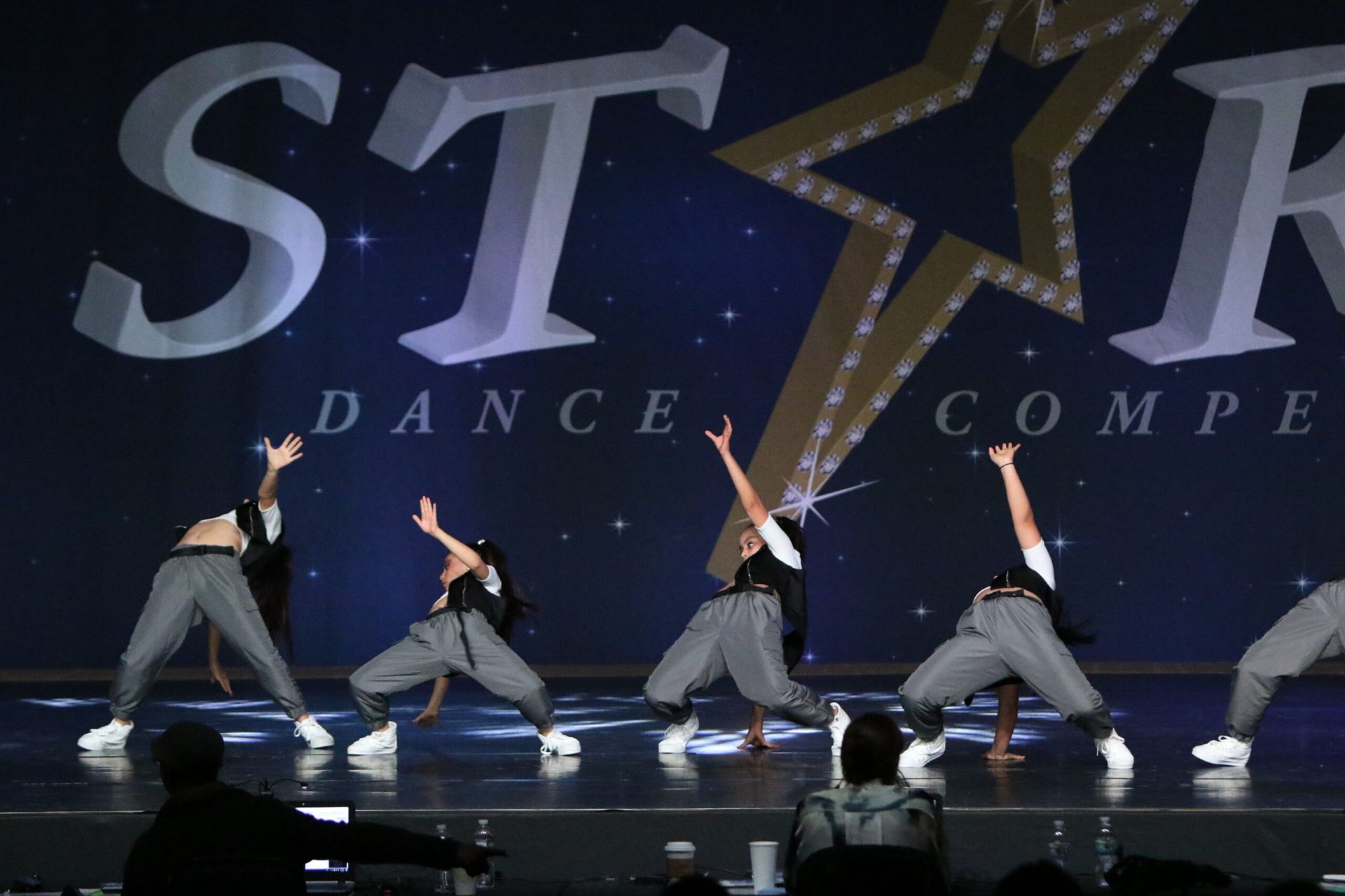 A group of dancers are performing in front of a sign that says star dance compe