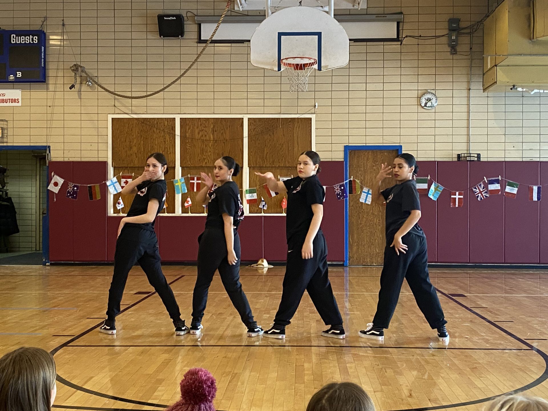 A group of people are dancing on a basketball court