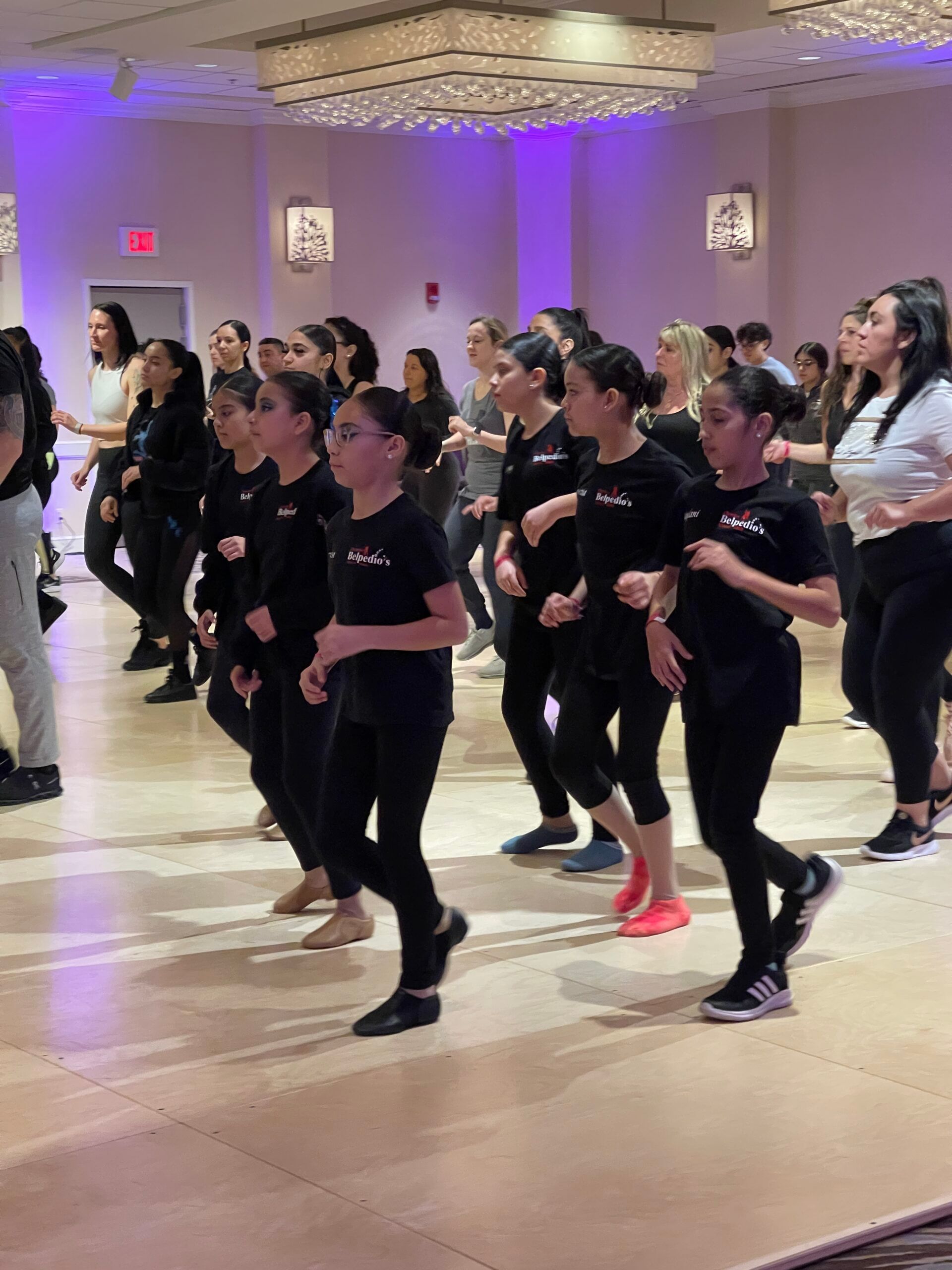 A group of women are dancing in a large room.