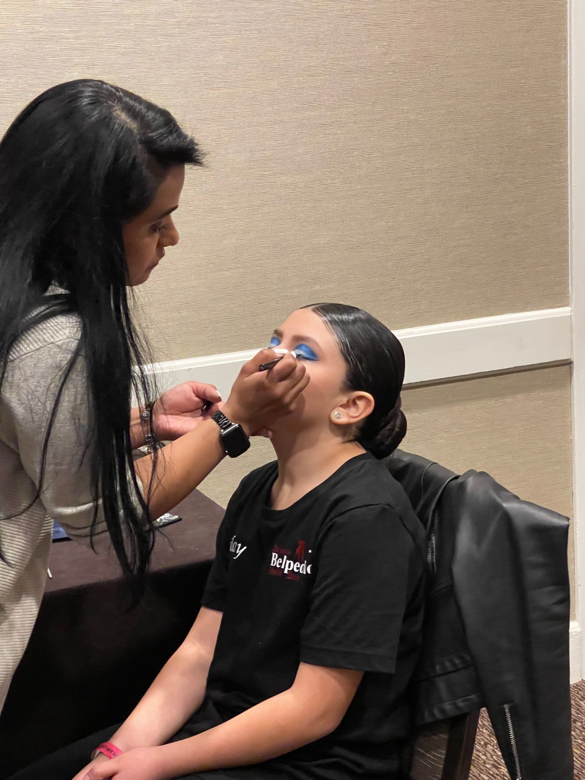 A woman is applying makeup to another woman 's face
