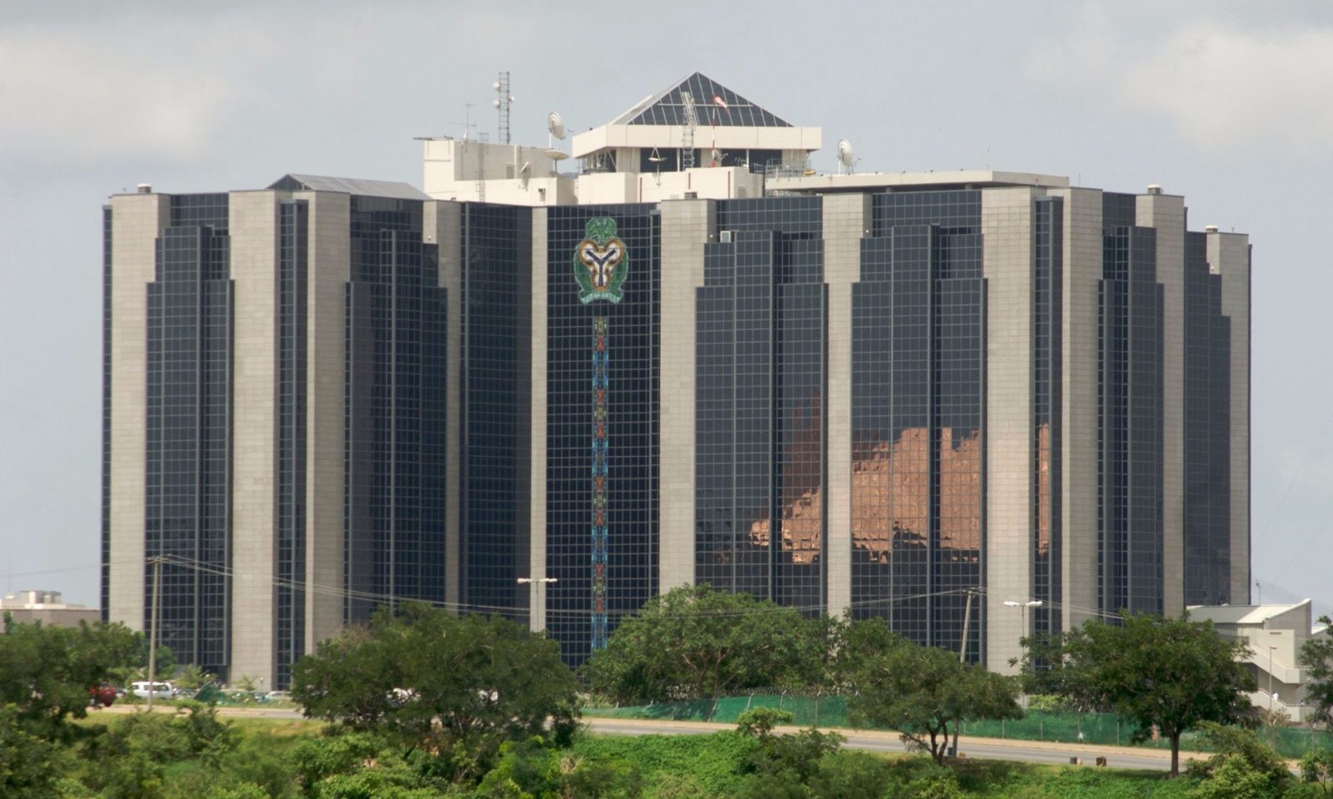 A large building with a lot of windows is surrounded by trees.