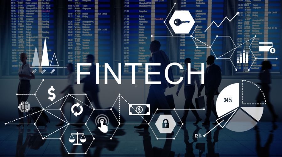 A group of people are walking in front of a screen that says fintech.