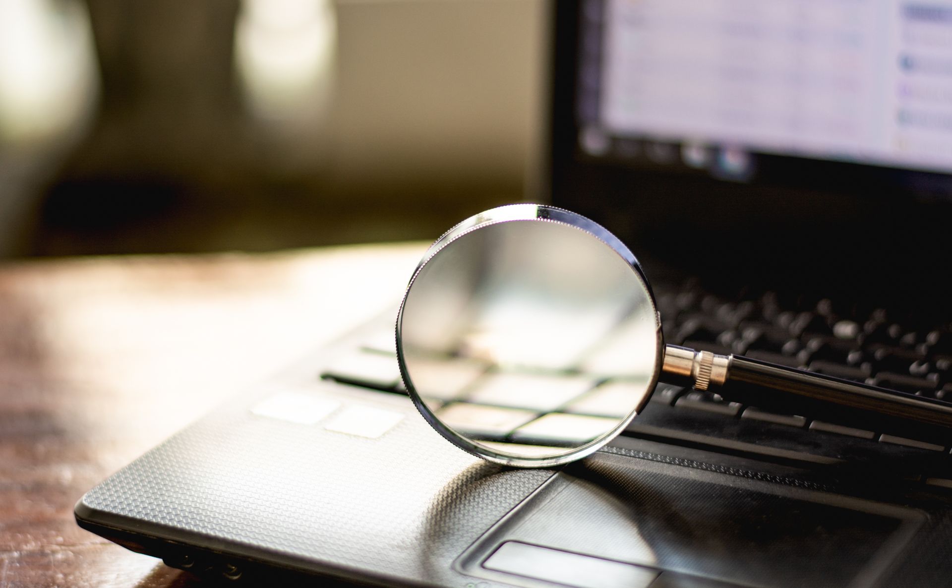Magnifying glass on a laptop keyboard.