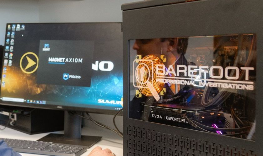 Computer setup with monitor displaying a logo and PC case showing components, including a graphics card with 