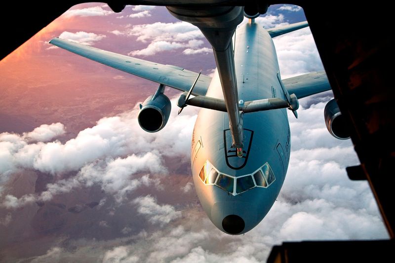 A KC-10 below the boom operator window at sunset
