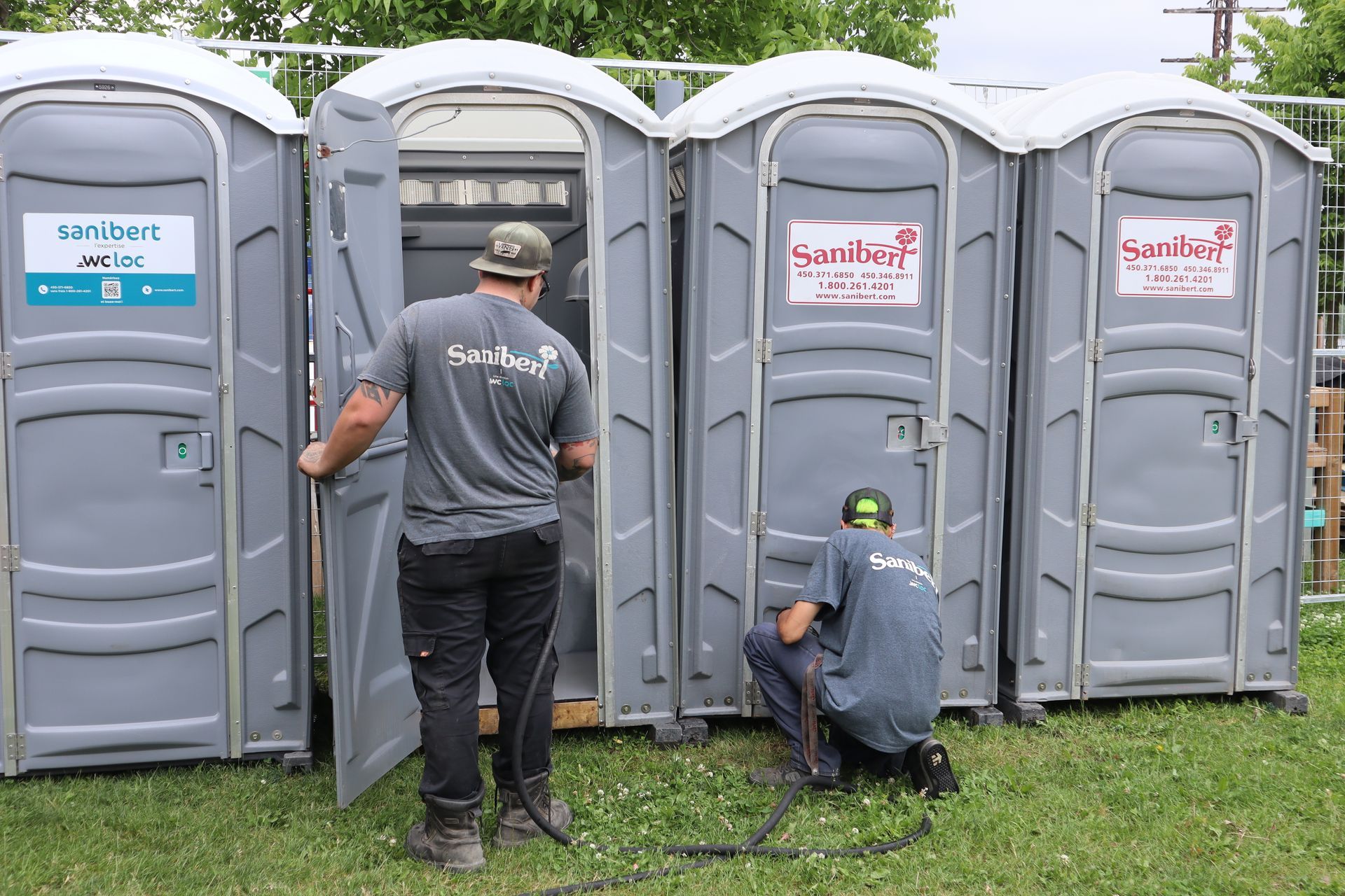 2 opérateurs sanitaires se chargeant de l'entretien et du nettoyage de toilettes chimiques lors d'un événement