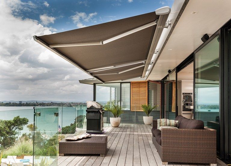 A balcony with a large awning over it and a view of the ocean.