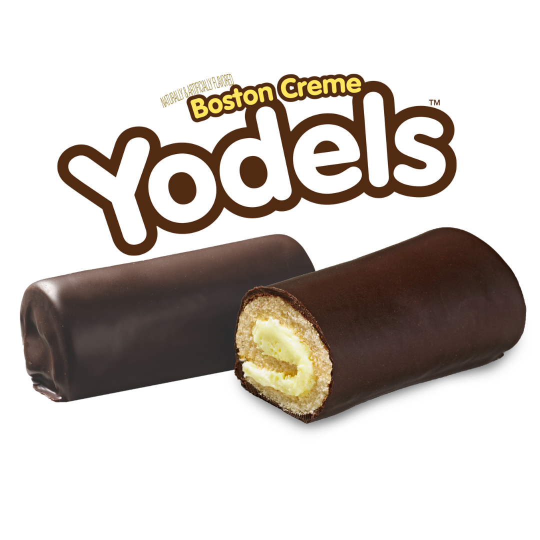 Two chocolate-covered Boston Creme Yodels cakes, one whole and one showing the cream filling, under the Yodels logo.
