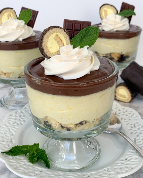 Close-up of a layered Boston Cream Parfait dessert made with Drake's Cakes Boston Creme Yodels, set against a yellow background.