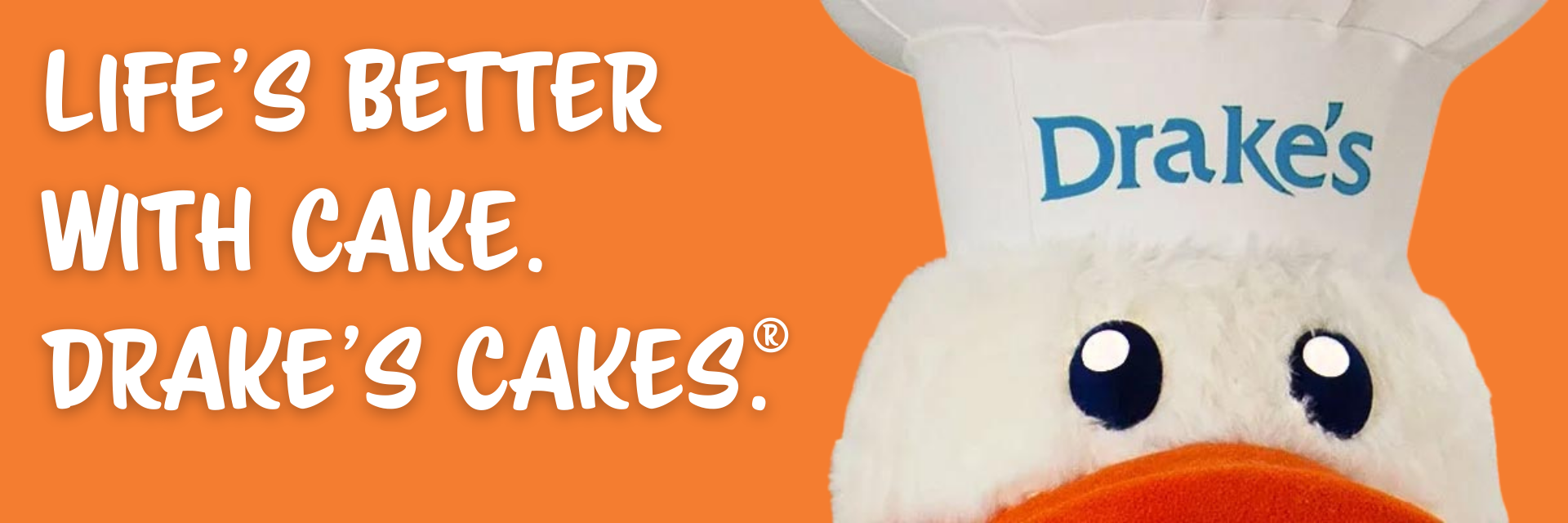 Drake’s Cakes ad with smiling white cake mascot and orange background, text: “Life’s Better With Cake.”