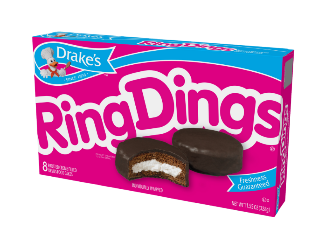 A box of Drake's Ring Dings featuring a pink background, brand logo, and chocolate-covered cakes with white cream filling.