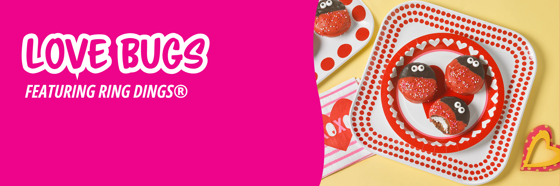 Pink banner promoting ladybug-decorated Ring Dings on patterned plates and a napkin with a heart, set against a yellow background.