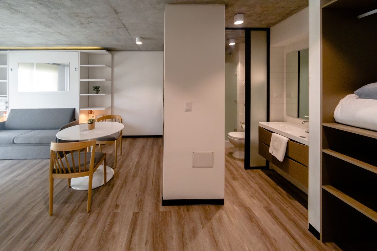 Interior de apartamento moderno con sala de estar, comedor y baño.