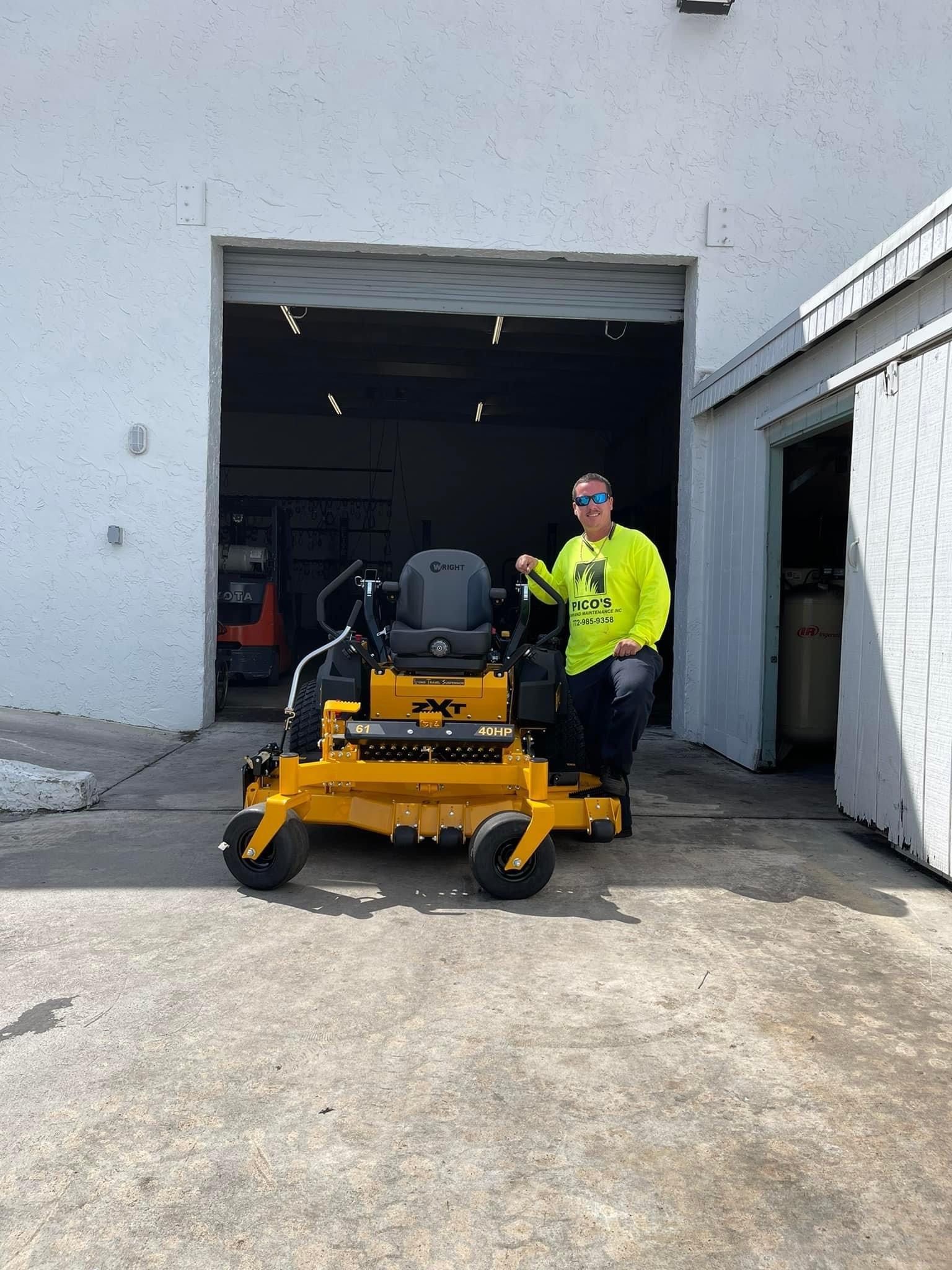 A man is standing next to a yellow lawn mower in front of a garage door.