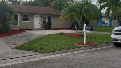 A white truck is parked in front of a house.