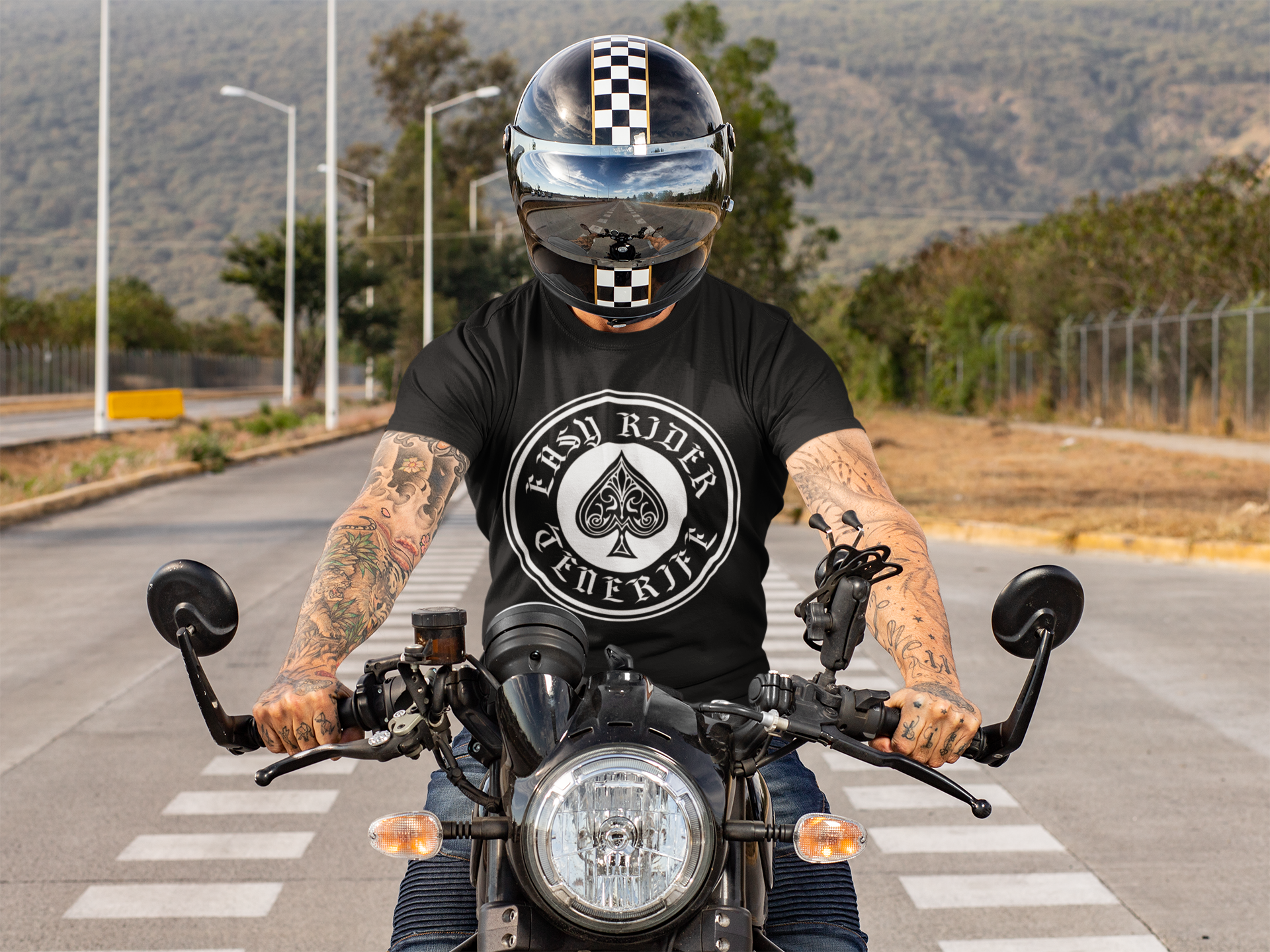 A man wearing a helmet is riding a motorcycle down a road.