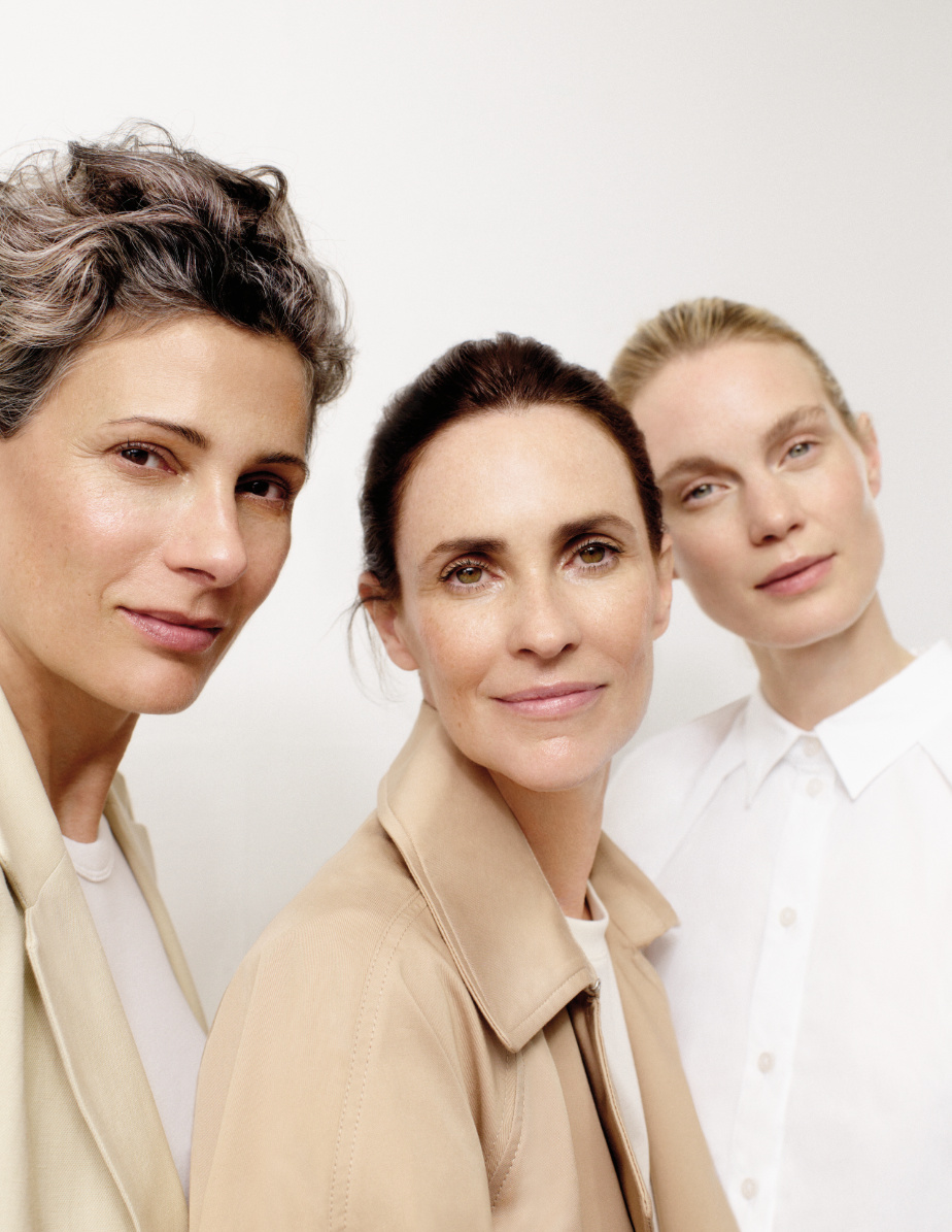 Three women are standing next to each other and smiling for the camera.
