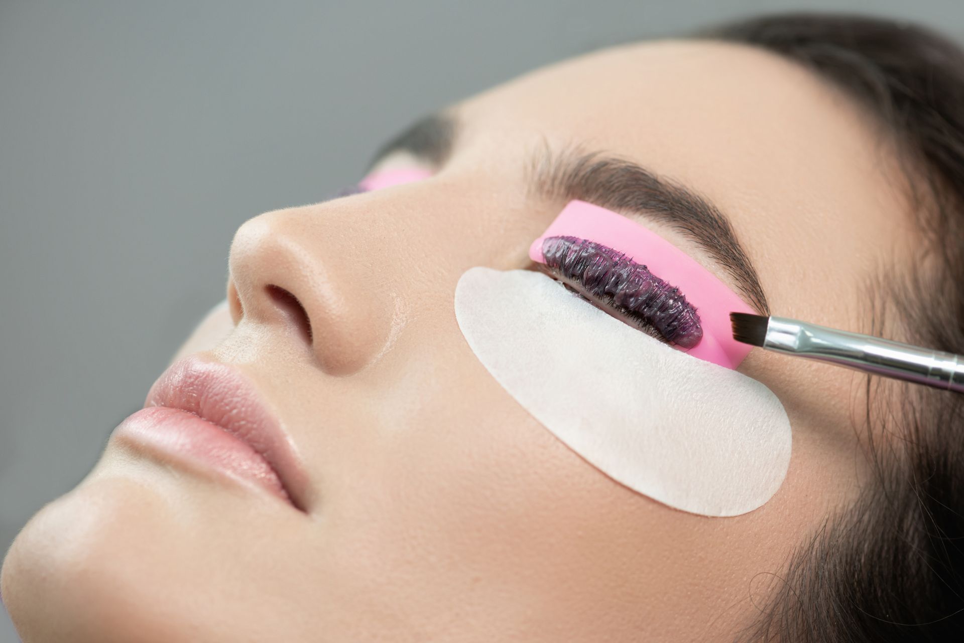 A woman is getting her eyelashes done in a beauty salon.