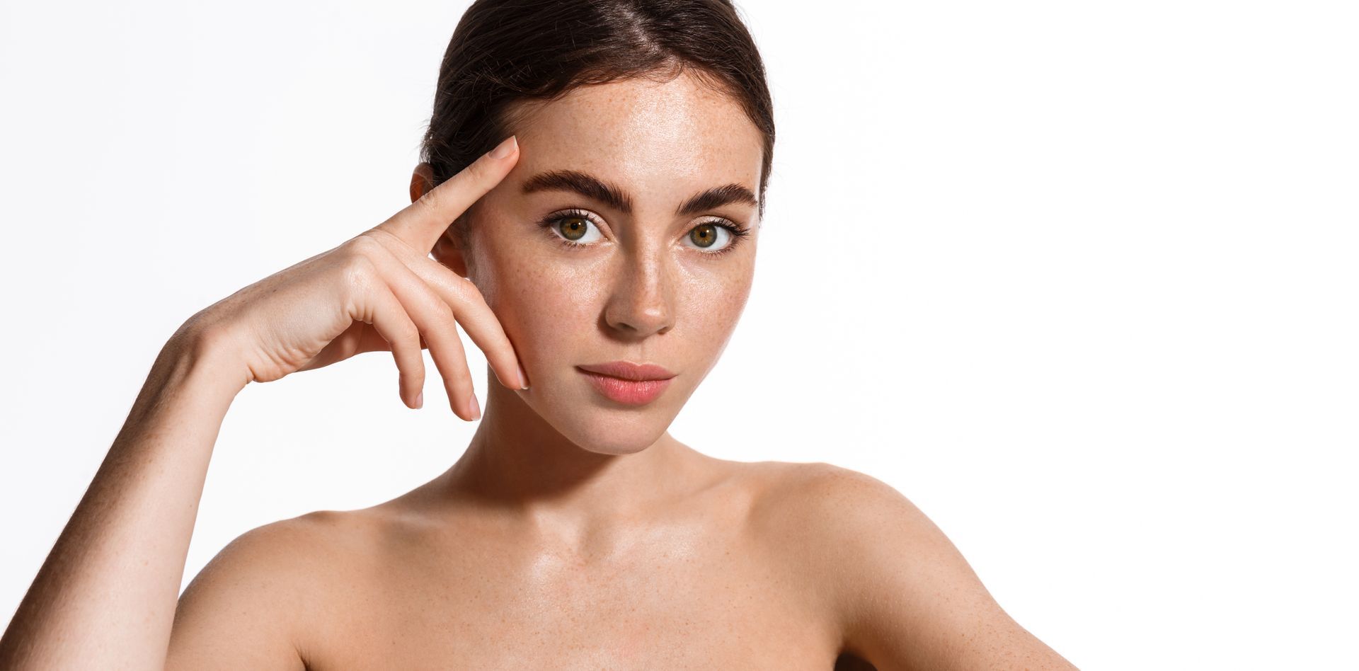A woman is touching her forehead with her hand.