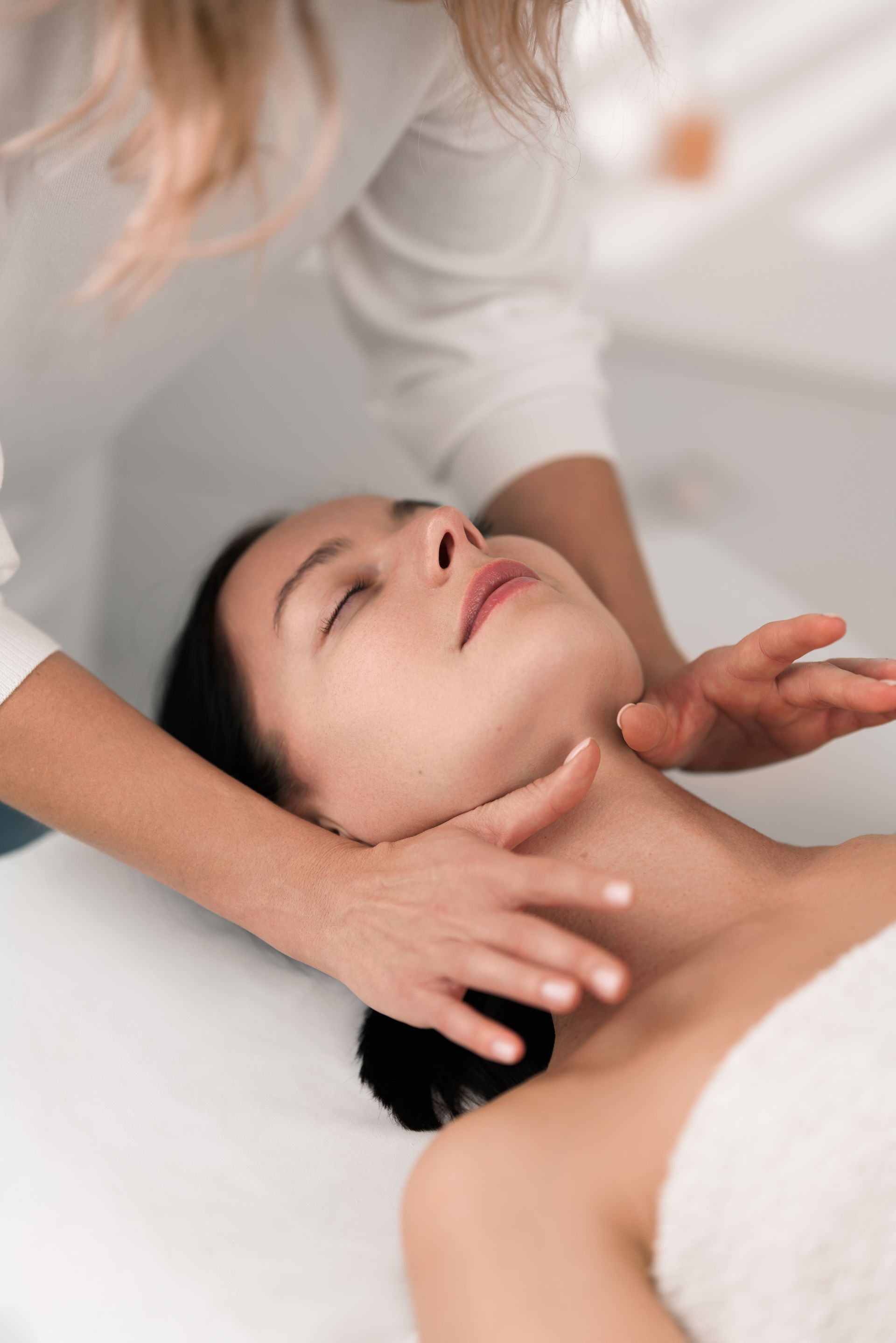 A woman is getting a neck massage at a spa.