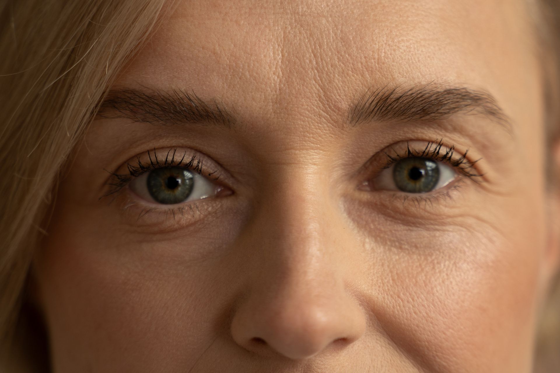 Close-up of a person’s eyes and nose, with a neutral expression and soft lighting