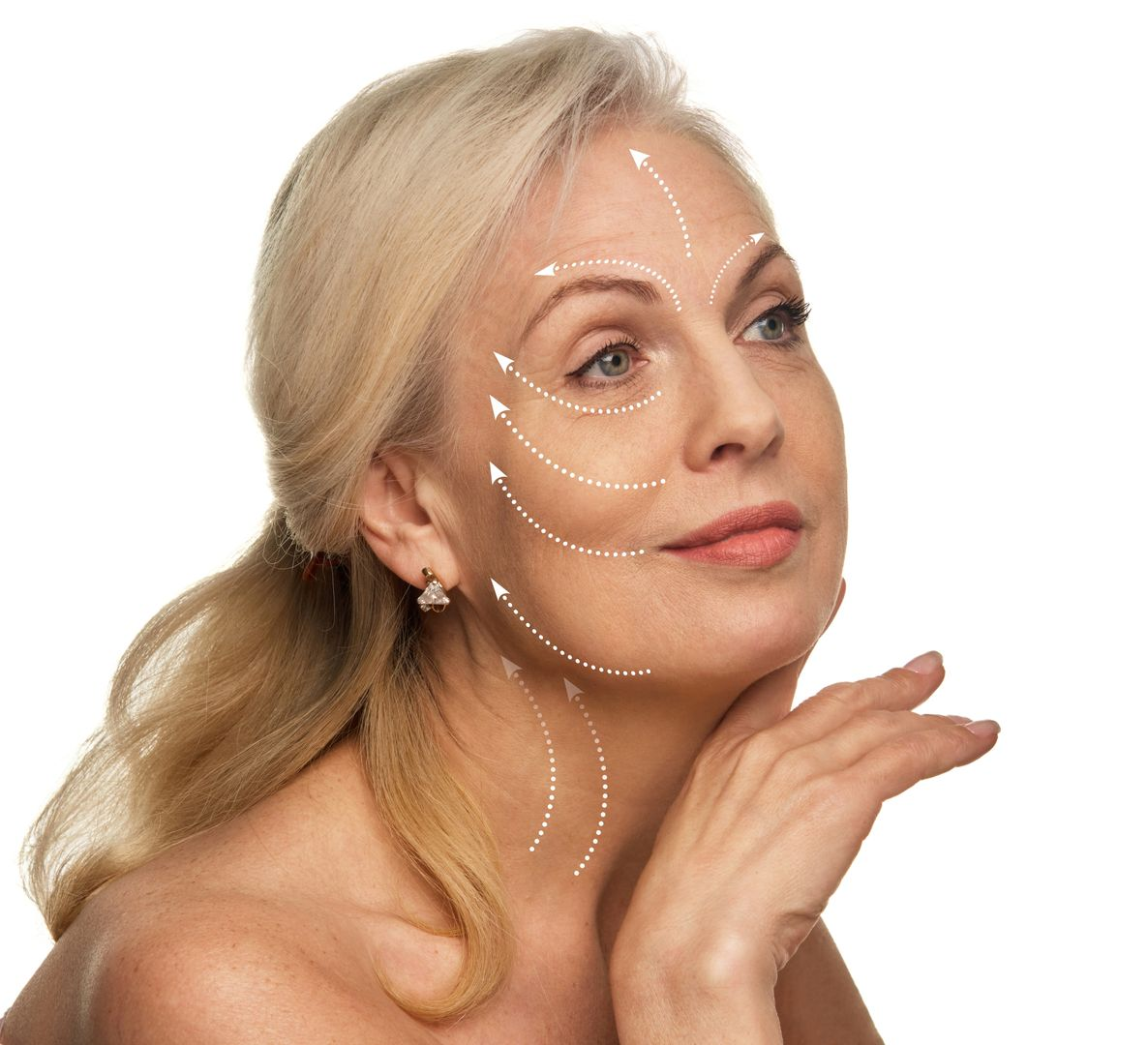 Blonde woman with white facial cream resting her chin on her hand against a white background