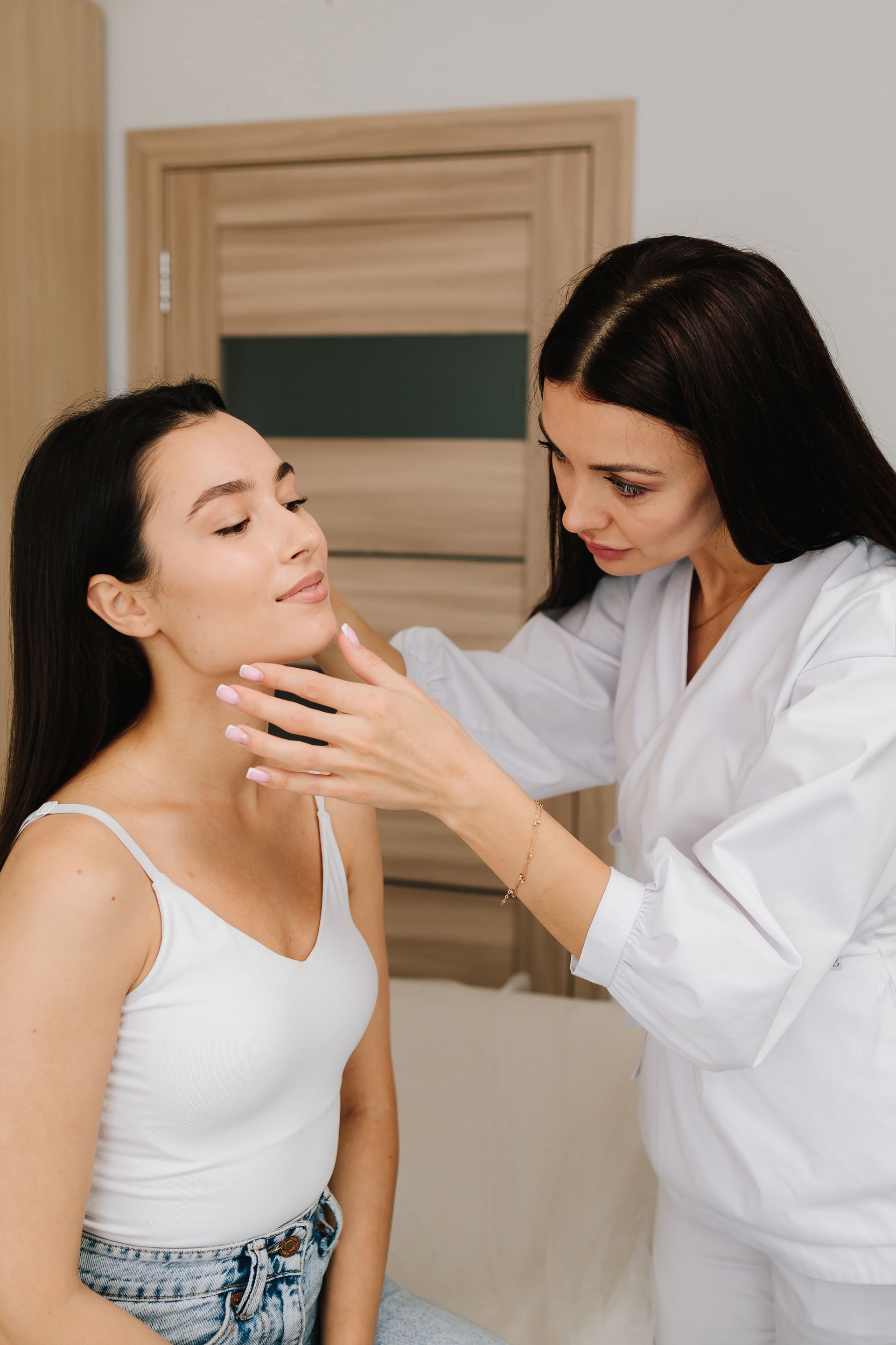 Clinician examining a patient’s neck in a bright medical room
