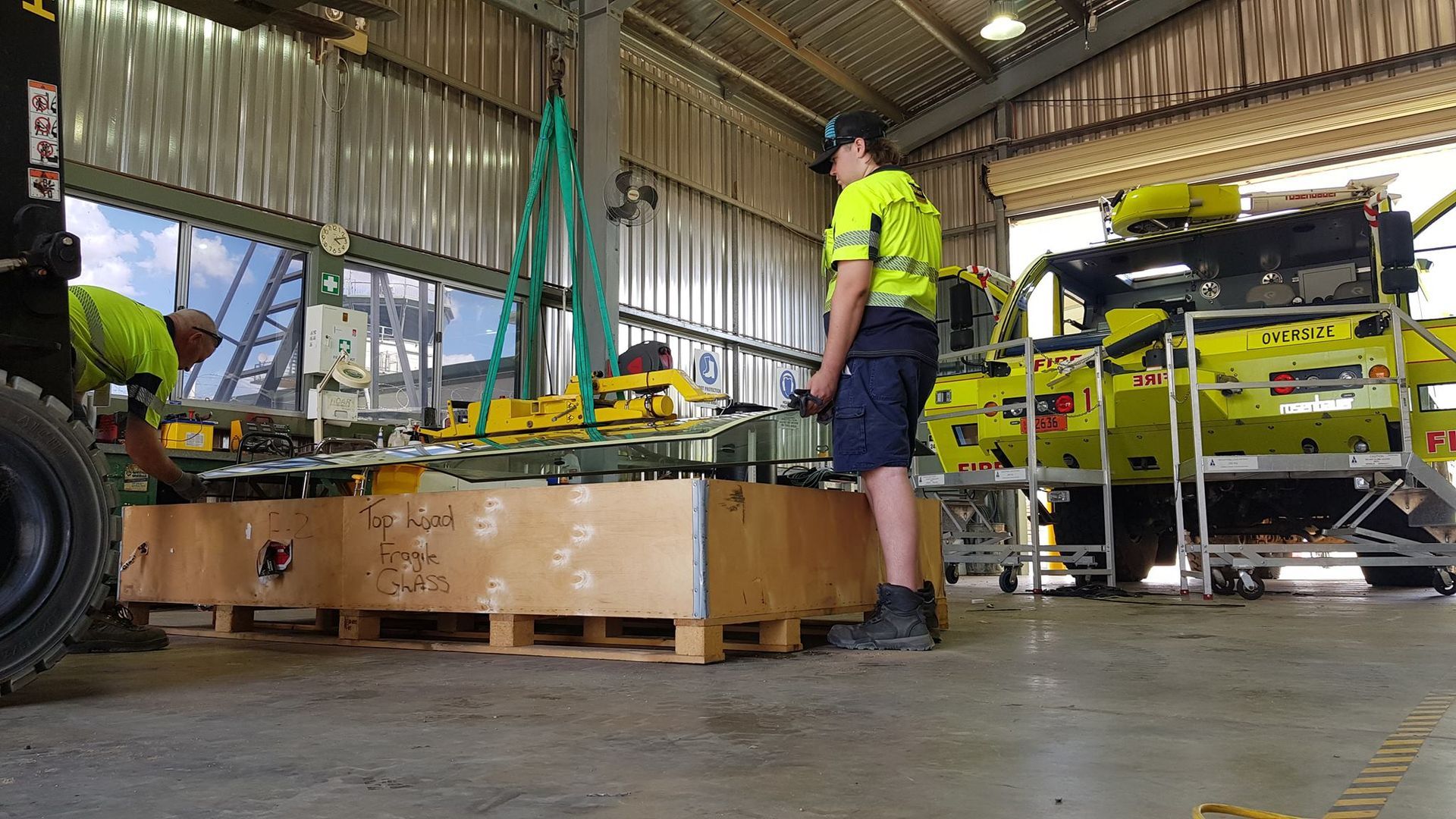 A Man is Standing Next to a Forklift in a Warehouse — Trusty Glass In Alice Springs, NT