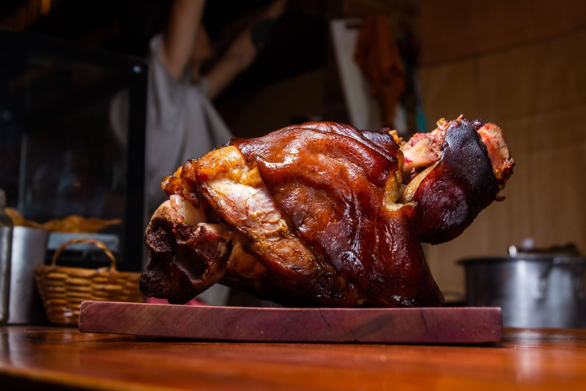 Roasted glazed pork on a wooden board in a warm kitchen setting