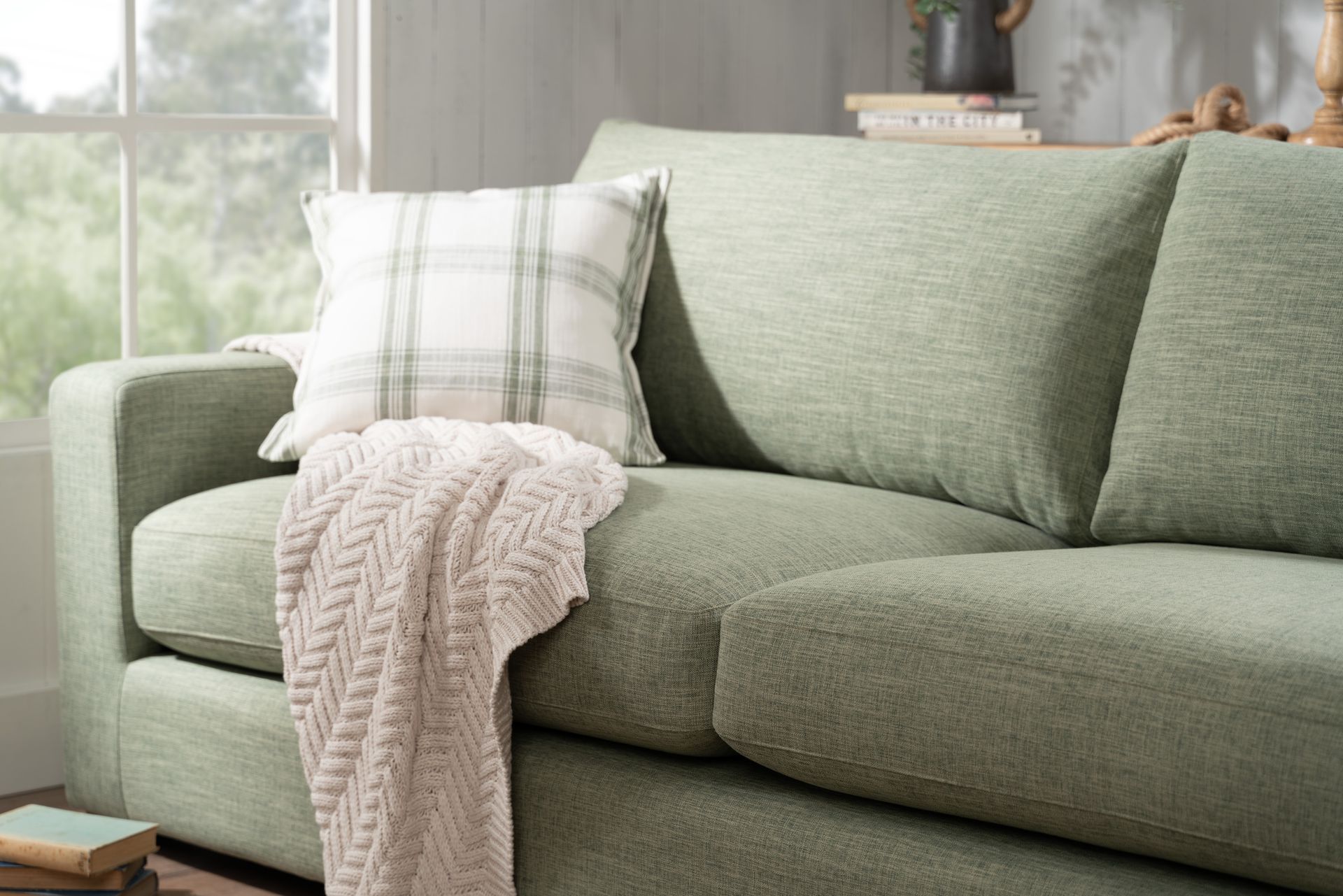 A Living Room With a green Sectional Couch and a White Coffee Table — Envisage Furniture in Kialla, VIC