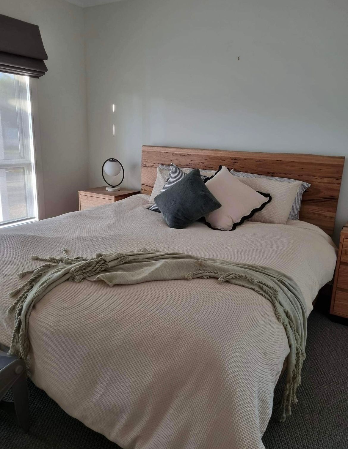 A bed with a white comforter and pillows in a bedroom.— Envisage Furniture in Kialla, VIC