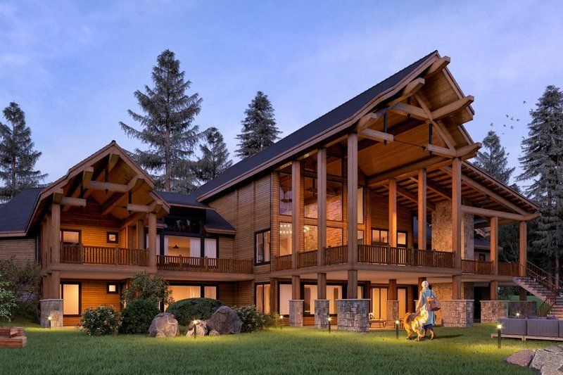 A large wooden house with a lot of windows is surrounded by trees.