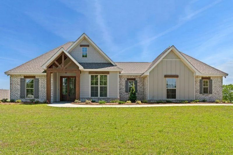 A large house with a lot of windows is sitting on top of a lush green field.