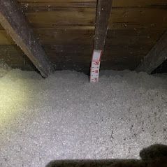 There is a measuring tape in the attic of a house.