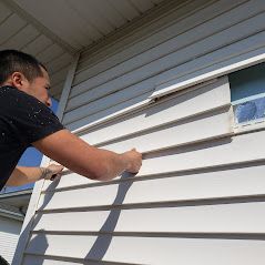 A man is painting the side of a house.