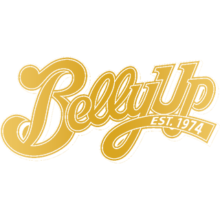 Gold, script-style logo for "Belly Up," featuring the text "EST. 1974" in a banner underneath, on a white background.